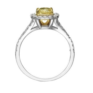 May include: A silver ring with a yellow gemstone set in a halo of smaller diamonds.