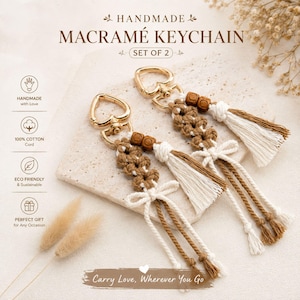May include: A set of two macramé keychains featuring heart-shaped gold-tone metal clasps, brown and cream cotton cord knots, wooden beads, and decorative tassels. The text HANDMADE MACRAMÉ KEYCHAIN SET OF 2 and Carry Love, Wherever You Go is visible.