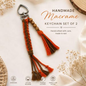 May include: A macrame keychain featuring orange and brown cotton cord, a silver heart-shaped metal clasp, and three wooden beads. The keychain includes a long tassel and text reading HANDMADE Macrame KEYCHAIN SET OF 2, Handcrafted with care, made to last.