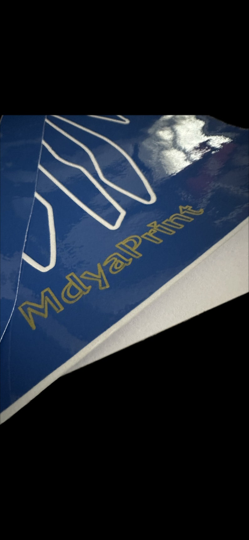Może przedstawiać: Zbliżenie na niebieską powierzchnię z białymi liniami i tekstem "MayalPrint" złotymi literami.
