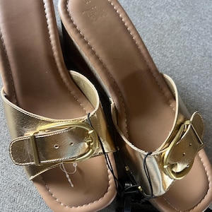 Puede incluir: Un par de sandalias doradas Time Tru con cu&ntilde;a. Las sandalias tienen punta cuadrada, cierre de hebilla y tac&oacute;n de cu&ntilde;a estilo corcho. Talla 10, nuevas con etiquetas.