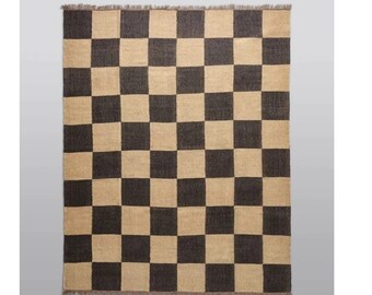May include: A black and beige checkered rug with a frayed edge.