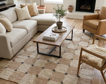 May include: A rectangular area rug featuring a large-scale checkered pattern in alternating shades of beige and tan. The woven texture includes small, dark-colored accent tufts at the corners of each square, creating a grid-like visual effect.