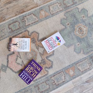 May include: Three self-help books on a beige rug with a blue and orange pattern. The books are titled "Think and Grow Rich" by Napoleon Hill, "How to Use Your Healing Power" by Dr. Joseph Murphy, and "The Power of Your Subconscious Mind" by Dr. Joseph Murphy.