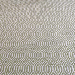 May include: A green and white patterned rug with a geometric design. The rug has a subtle sheen and a soft texture.