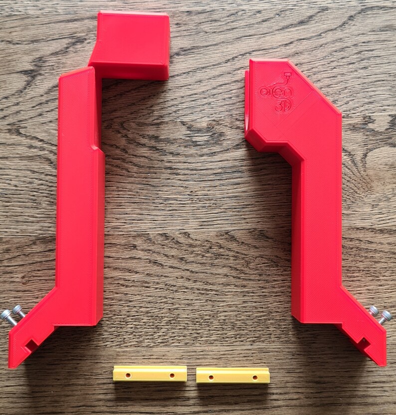 May include: Two red 3D printed plastic brackets with two yellow plastic spacers. The brackets have a logo that says "Open 3D".