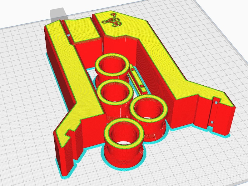 May include: A 3D printed red and yellow object with three cylindrical holes. The object is designed to hold multiple items.