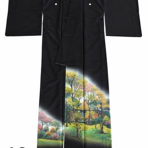 May include: A black kimono with a landscape design. The kimono features a black exterior with a colorful landscape scene at the bottom, including trees and a building. The text "A2" is visible in the lower left corner.