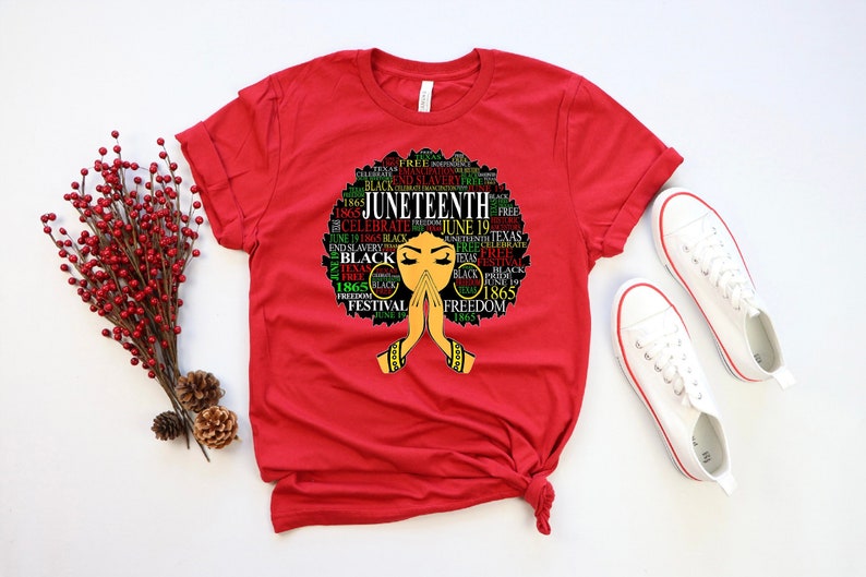 May include: Red t-shirt with a black and green graphic of a woman's face with the words "Juneteenth" and "Freedom" in a circle around her head.