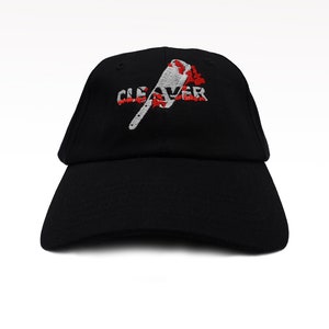 May include: Black baseball cap with the word "CLEAVER" embroidered in white and red, along with a cleaver graphic. The cap has a curved brim and a classic, adjustable design.