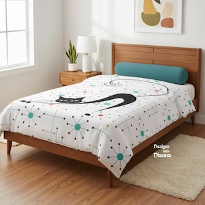 May include: A white bedspread with a black cat design and a mid-century modern pattern of teal, yellow, and red dots and lines. The bedspread is on a wooden bed frame with a teal bolster pillow.