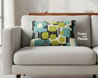 May include: A rectangular throw pillow featuring a geometric pattern of rounded squares and rectangles in shades of lime green, teal, black, and off-white. The text "Designs with Dianna" is printed in white on the right side of the pillow.