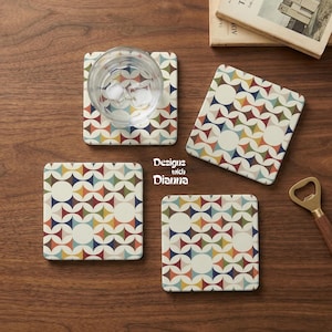 May include: Four square coasters with a retro geometric pattern in shades of red, blue, yellow, and green on a cream background. One coaster holds a glass of water with ice. The coasters are on a wooden surface. The text "Designs with Dianna" is visible.