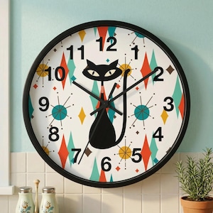 May include: A black-framed wall clock with a white face featuring a black cat silhouette and a mid-century modern design. The clock face has a pattern of diamonds in red, teal, and yellow, with black hands and numerals.