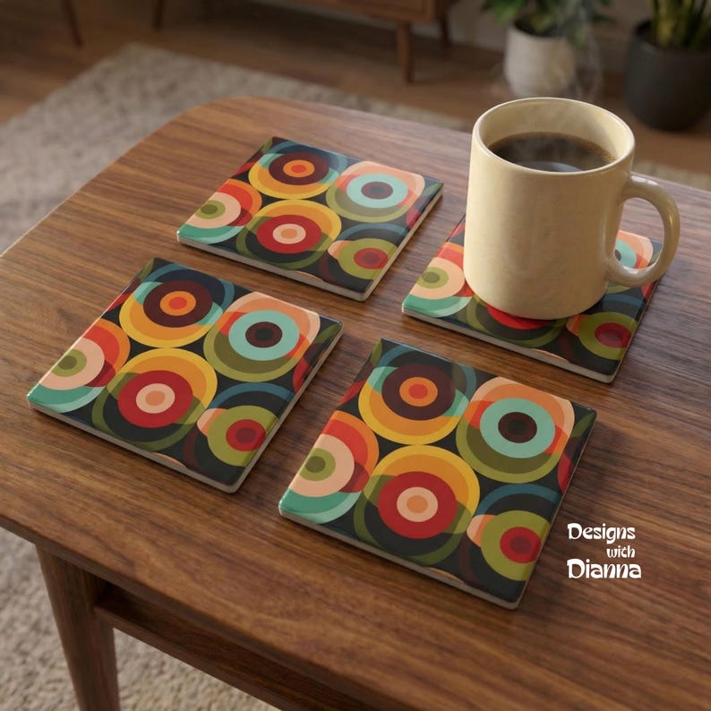May include: Set of four square coasters with a retro design. Each coaster features a repeating pattern of colorful circles in shades of orange, yellow, green, and teal on a dark background. A beige mug with coffee sits on one coaster.