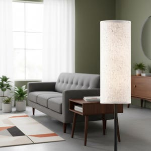 May include: A tall floor lamp featuring a cylindrical, off-white fabric shade with a visible woven texture. The lamp is supported by a slender, dark-colored metal pole that extends vertically, providing a clean and functional lighting design.