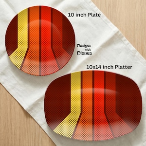 Puede incluir: Un plato de 25 cm y una fuente de 25x36 cm con un dise&ntilde;o retro. Los platos presentan un patr&oacute;n de rayas verticales en tonos amarillos, naranjas y rojos, con una textura punteada. El texto "Designs with Dianna" es visible.