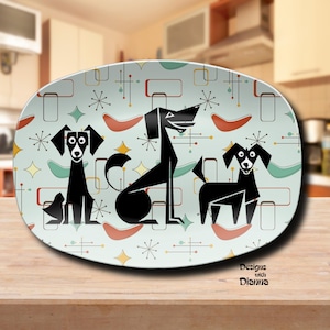 May include: An oval serving platter with a retro design featuring three stylized black dogs on a light blue background. The background includes geometric shapes and starbursts in various colors. The platter has the text "Designs with Dianna".