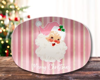 May include: Pink oval serving platter with a vintage Santa Claus illustration and the text "Merry Christmas".