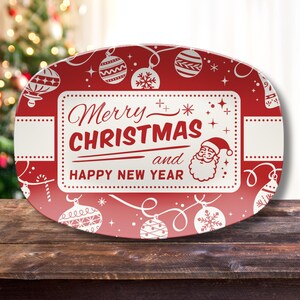 May include: Red and white oval serving platter with a Christmas theme. The platter features the text "Merry Christmas and Happy New Year" in a rectangular frame, along with Santa Claus and Christmas ornaments.