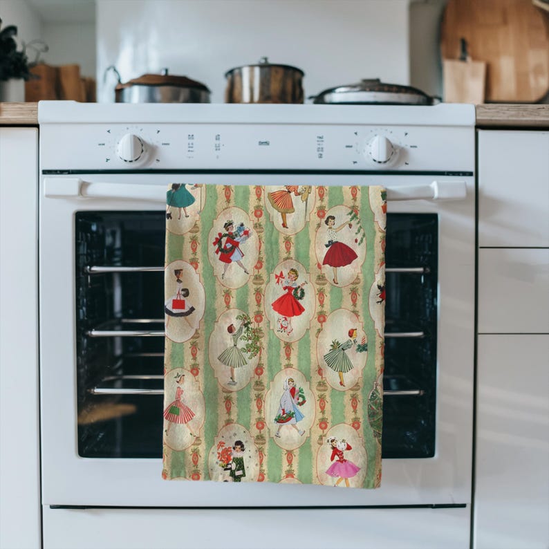 May include: A kitchen towel with a vintage design featuring illustrations of women in dresses. The towel has a green and white striped background with oval frames. The women are wearing dresses in various colors, including red, green, and pink.