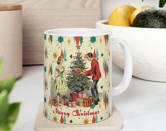 Puede incluir: Una taza de cerámica blanca con una ilustración de estilo mediados de siglo de una persona con vestido verde y otra con blazer rojo intercambiando un regalo junto a un árbol de Navidad. El fondo tiene un patrón de diamantes y estrellas con el texto Merry Christmas.