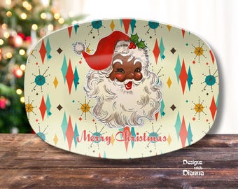 May include: Oval serving platter with a retro design featuring Santa Claus with a red hat and white beard. The platter has a cream background with a pattern of diamonds and starbursts. The words "Merry Christmas" are written on the platter.
