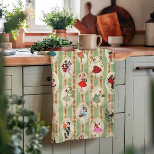May include: A kitchen towel with a vintage design featuring illustrations of women in dresses. The towel has a green and white striped background with oval frames. The women are dressed in various outfits and poses.
