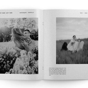 May include: A black and white photo of a couple in a field of flowers. The woman is holding onto the man's shoulders and her hair is blowing in the wind. The man is looking at the camera.