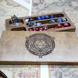 May include: A wooden box with a lid that opens to reveal compartments for dice. The lid has a laser-engraved design of a 20-sided die surrounded by a circle of symbols.