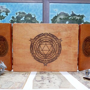 May include: A wooden box with three hinged panels, each featuring a laser-engraved design. The center panel shows a stylized d20 dice surrounded by a circular pattern. The box is ideal for storing and organizing game pieces.