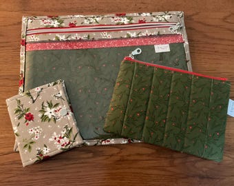 May include: A set of fabric pouches and a wallet. The large pouch has a floral pattern with red and white flowers on a tan background. The smaller pouch is olive green with a red zipper and a quilted design. The wallet has a floral pattern.