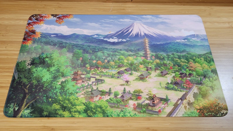 May include: A colorful illustration of a Japanese village with a pagoda and Mount Fuji in the background. The village is surrounded by lush green trees and a stone wall.
