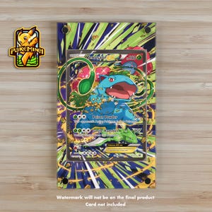 Puede incluir: Una vitrina de acrílico transparente con un fondo verde, azul y amarillo. La vitrina presenta una carta de Pokemon con una imagen de Venusaur, un Pokemon de tipo planta. La carta tiene el texto "Venusaur EX" y "Basic" en ella.