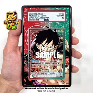 May include: A collectible trading card featuring Monkey D. Luffy from the One Piece anime series. The card is in a protective case with a red, white, and green background. The card has a power level of 5000 and is a leader card. The card is from the Supernovas/Straw Hat Crew set.