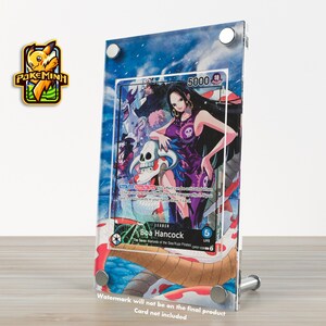 May include: A clear acrylic display stand holding a trading card featuring Boa Hancock from the One Piece series. The card has a purple and black color scheme with a skull and crossbones design. The stand is held together with silver metal screws.