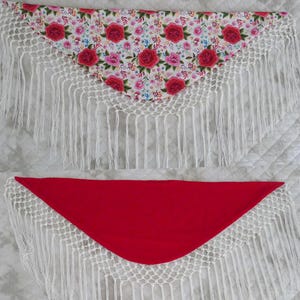May include: Two triangular shawls. The top shawl has a floral pattern with red and pink roses on a white background. The bottom shawl is solid red. Both shawls have white crocheted edges with long fringe.