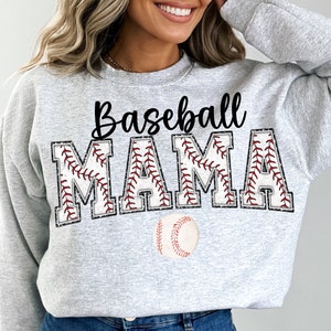 Könnte beinhalten: Ein grauer Pullover mit dem Text "Baseball Mama" in schwarzen Buchstaben. Die Buchstaben sind mit roten Nähten umrandet, und unter dem Text ist ein Baseball abgebildet.