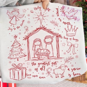 The Greatest Gift of All text design with hand-drawn nativity scene doodle illustration