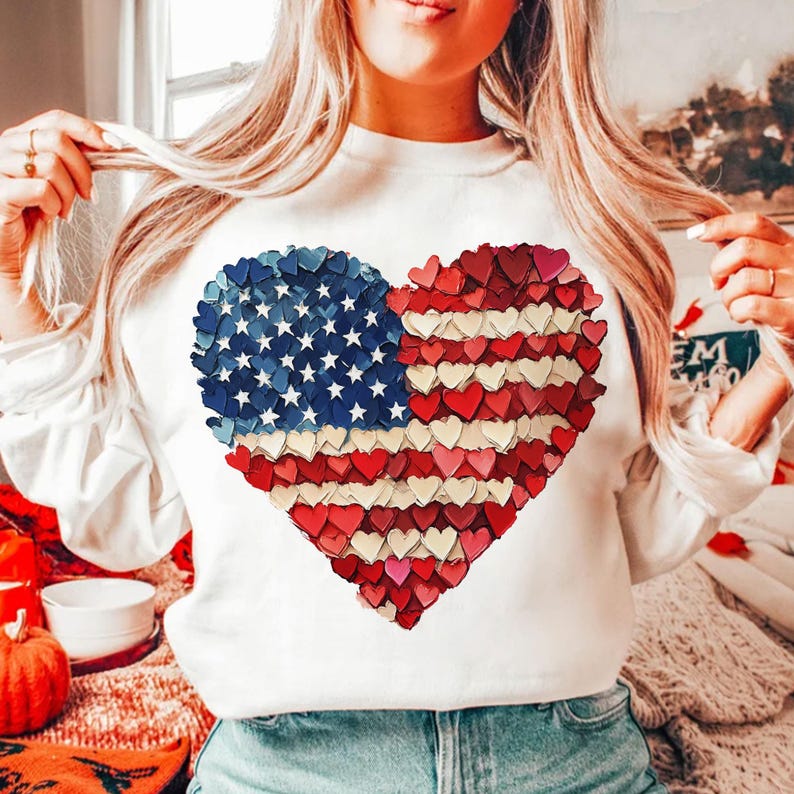 May include: White sweatshirt with a red, white, and blue heart-shaped American flag design made of small hearts.