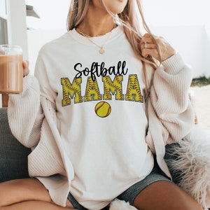 May include: White sweatshirt with the text "Softball Mama" in black lettering with a yellow softball graphic.