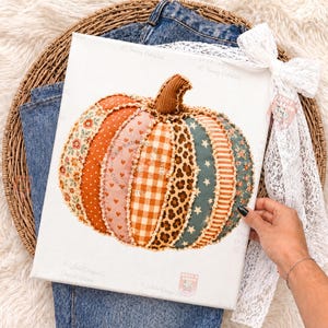 May include: A rectangular canvas print featuring a central pumpkin illustration composed of various fabric-like segments. The segments display diverse patterns including floral prints, hearts, orange gingham, leopard spots, and stars in autumn colors.