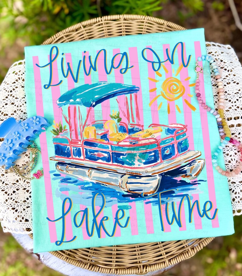 May include: A turquoise and pink striped canvas features a pontoon boat illustration with the words "Living on Lake Time" in cursive. The boat has a blue canopy and is surrounded by water and a yellow sun.