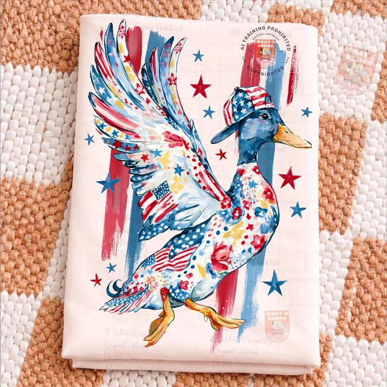 May include: A folded, pale pink fabric displays a whimsical duck illustration. The duck is decorated with patriotic patterns, including the American flag, stars, and stripes. It wears a matching cap and has red, white, and blue accents.