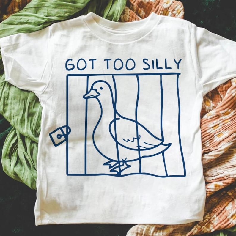 May include: White t-shirt with a blue graphic of a goose in a cage. The text "GOT TOO SILLY" is above the goose.