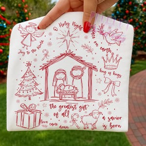 K&ouml;nnte beinhalten: Wei&szlig;er Stoff mit roten Strichzeichnungen zum Thema Weihnachten. Dargestellt sind ein Engel, ein Weihnachtsbaum, eine Krippe, ein Geschenk und ein Schaf. Der Text lautet "Joy to the World", "O Holy Night" und "Peace on Earth".