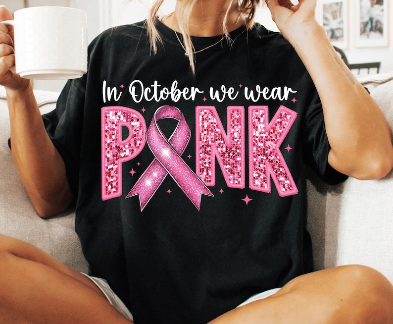 May include: Black t-shirt with the text "In October we wear PINK" in white with a pink sparkly ribbon and stars.