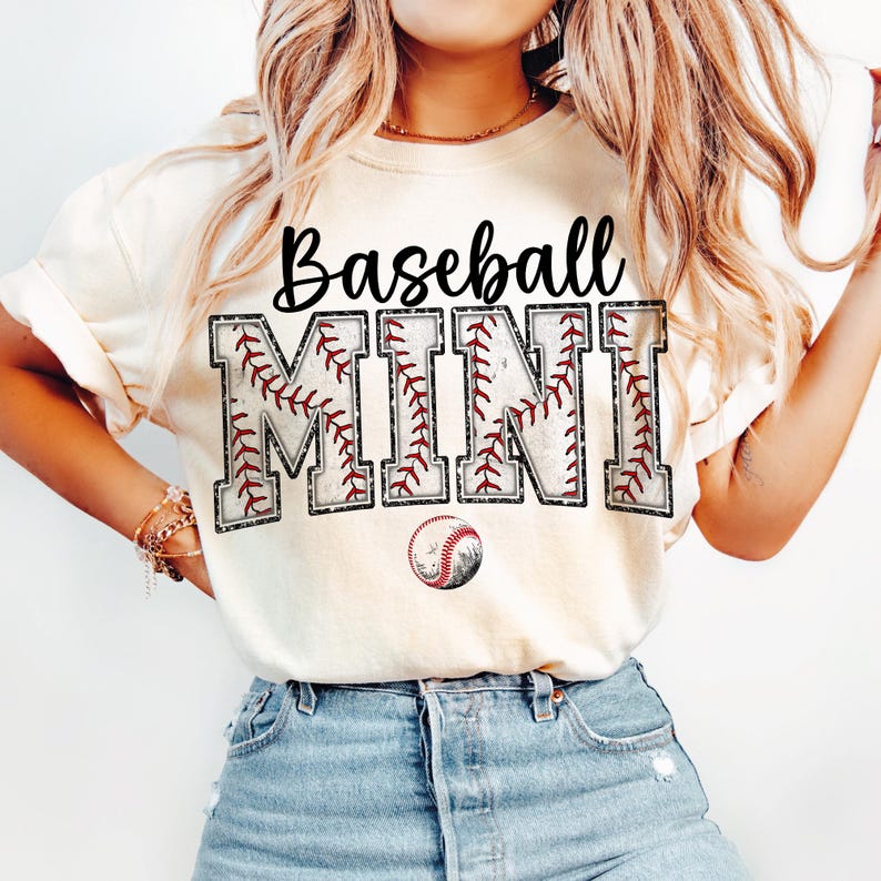 May include: A white t-shirt with the text "Baseball Mini" in black and red lettering. The letters are decorated with a baseball stitch pattern. A small baseball graphic is below the text.