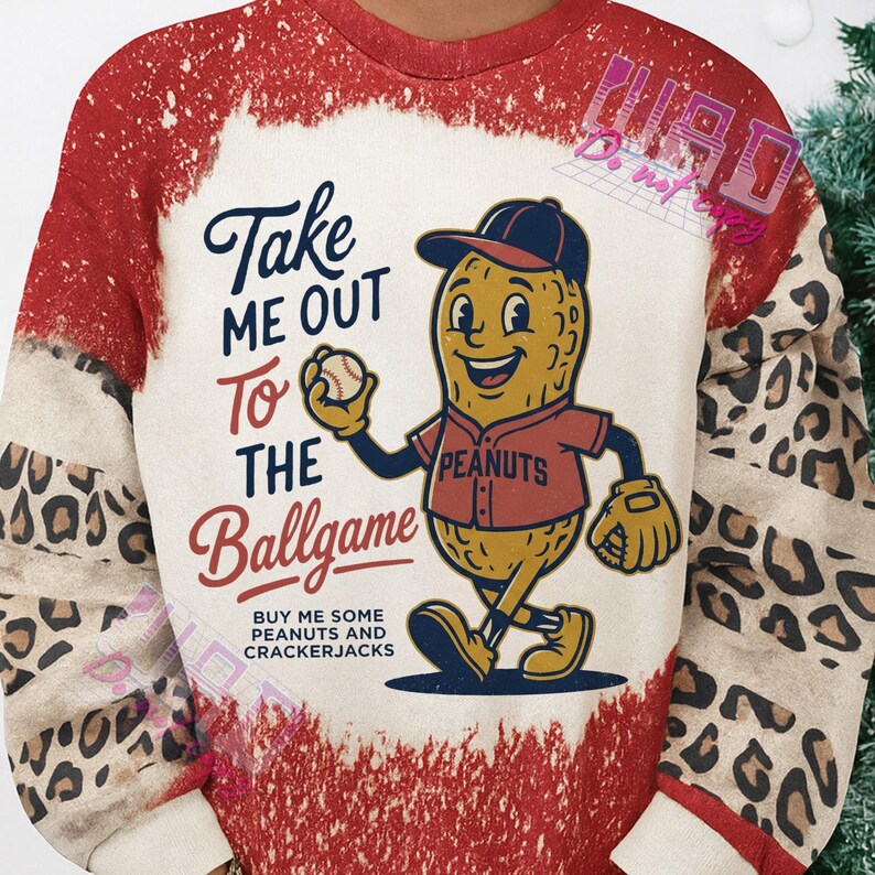 May include: A baseball-themed sweatshirt with a distressed red and cream design. The front features a cartoon peanut character in a baseball uniform holding a baseball. Text reads "Take Me Out To The Ballgame" and "Buy Me Some Peanuts and Crackerjacks."