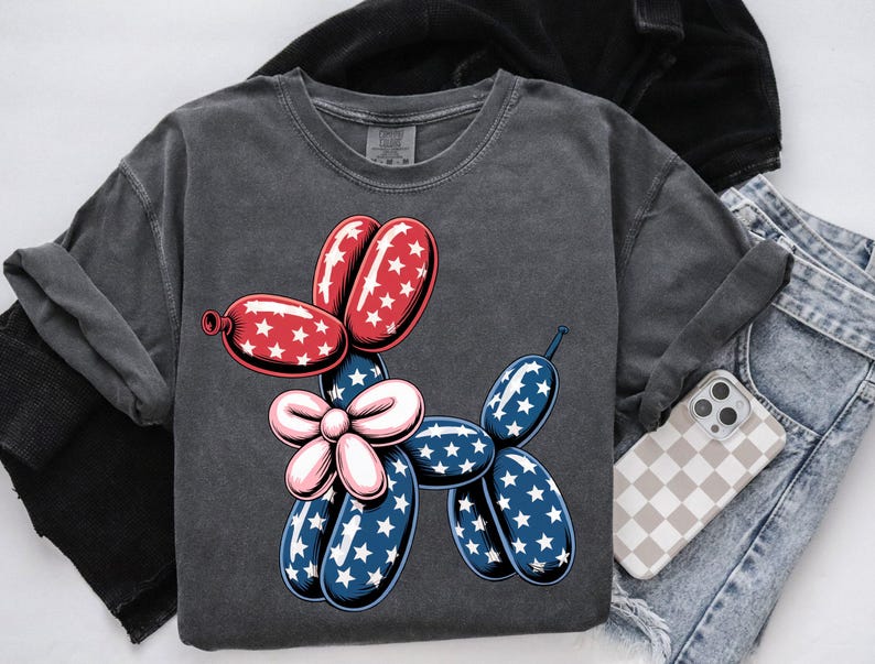 May include: A dark gray t-shirt with a red, white, and blue balloon dog graphic. The balloon dog is shaped like a dachshund and has a bow.